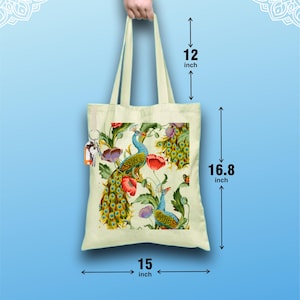 Peut inclure: Un sac fourre-tout cr&egrave;me avec un motif de paon et de fleurs. Le sac mesure 38 cm de large, 43 cm de haut et poss&egrave;de des anses de 30 cm. Le texte en bas indique : L&eacute;ger - Durable - Longue poign&eacute;e.