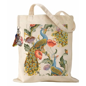 Peut inclure: Sac fourre-tout en toile de couleur cr&egrave;me avec un motif de paon et de fleurs. Le motif comprend des paons bleus, des coquelicots rouges et des feuilles vertes. Le sac a une poign&eacute;e assortie et un porte-cl&eacute;s avec des breloques color&eacute;es.