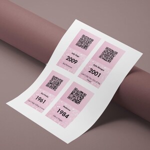Pode incluir: Uma folha branca com quatro autocolantes cor-de-rosa e brancos. Cada autocolante apresenta um c&oacute;digo QR, o nome do artista, o ano e o t&iacute;tulo da m&uacute;sica. Os artistas s&atilde;o Lady Gaga, Kylie Minogue, Elvis Presley e Madonna. Os anos s&atilde;o 2009, 2001, 1961 e 1984. As m&uacute;sicas s&atilde;o 'Bad Romance', 'Can't Get You Out of My Head', 'Can't Help Falling in Love' e 'Like a Virgin'.