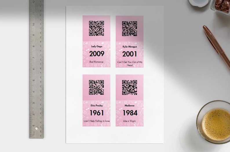 May include: Four pink cards with QR codes and text. The cards feature Lady Gaga (2009), Kylie Minogue (2001), Elvis Presley (1961), and Madonna (1984). Each card displays the artist's name, the year, and a song title.