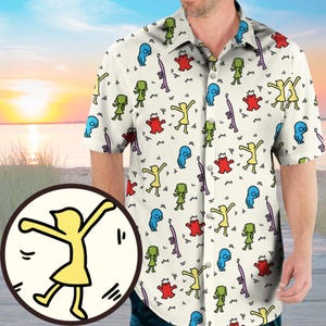 Puede incluir: Camisa de manga corta color crema con un estampado repetido de figuras de dibujos animados coloridas. El diseño incluye personas bailando, extraterrestres y formas abstractas en amarillo, verde, rojo y azul. La camisa tiene cuello clásico y cierre de botones.