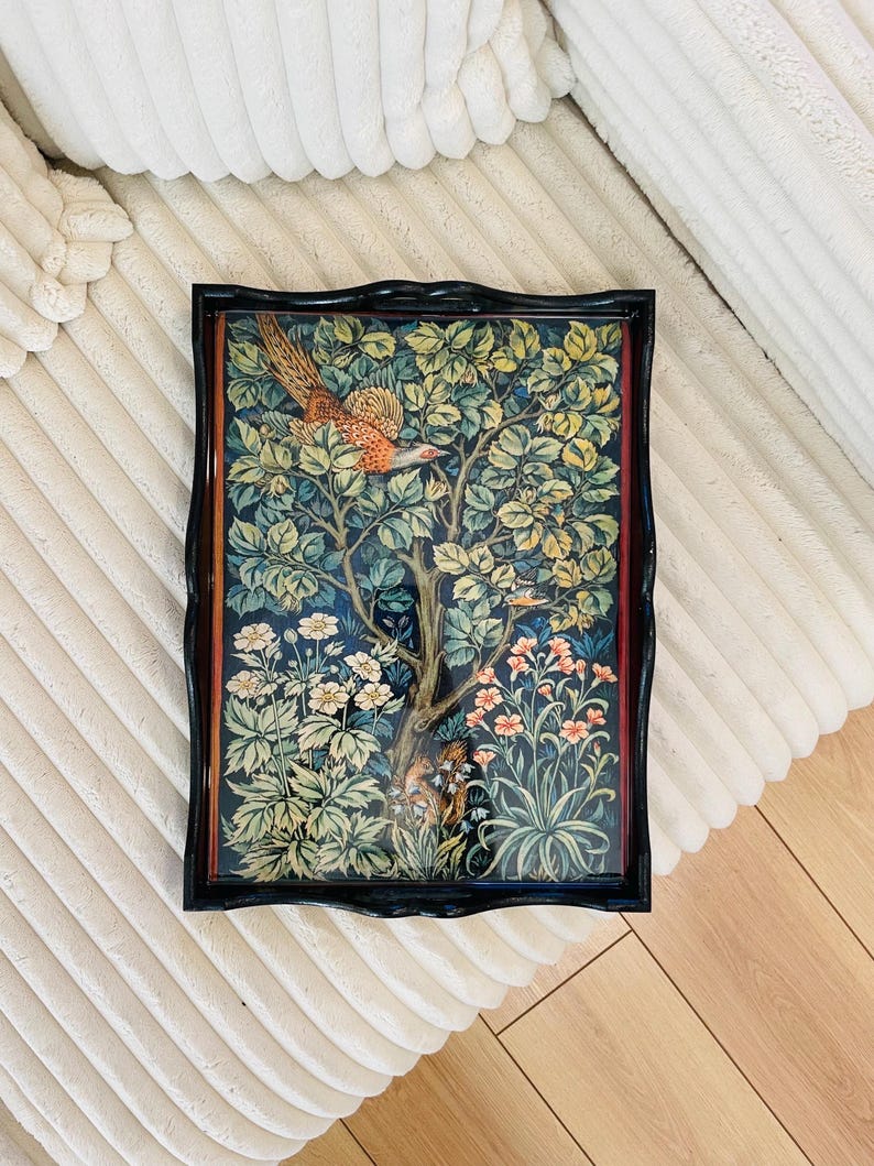 Puede incluir: Una bandeja negra con un borde elevado y un dise&ntilde;o floral con un p&aacute;jaro y flores. La bandeja tiene un acabado de madera oscura y una superficie brillante.