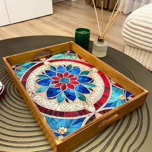 May include: A wooden serving tray with a colorful mosaic design featuring a blue, red, and green floral pattern. The tray has two handles on the sides.