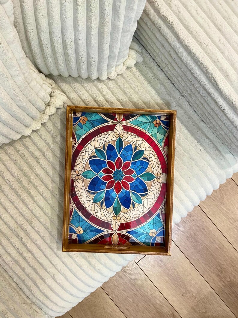May include: A wooden serving tray with a stained glass design featuring a red, blue, and white circular pattern. The tray has a handle on one side.