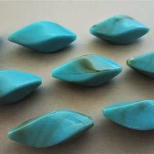 May include: Eight turquoise blue and green marbled glass beads in a teardrop shape.