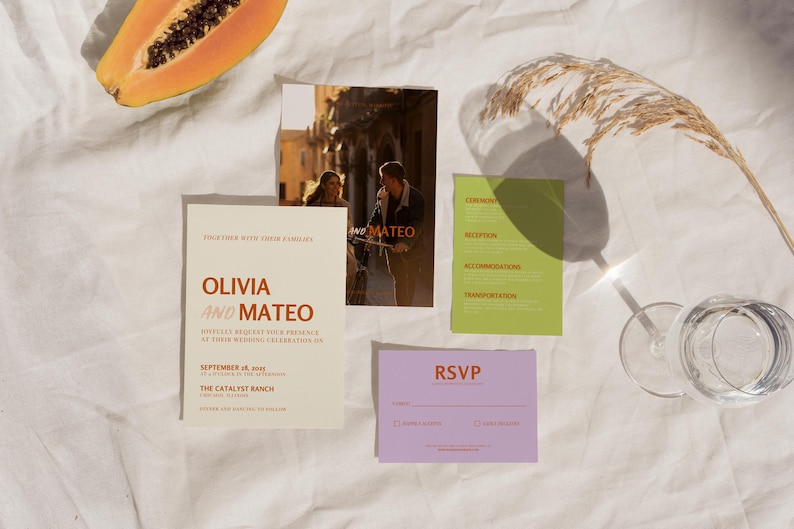 May include: Wedding invitation suite with a cream background. The main invitation features the names Olivia and Mateo in orange text. The RSVP card is purple with the text RSVP in orange. The information card is green with the text Ceremony, Reception, Accommodations, and Transportation in black text.
