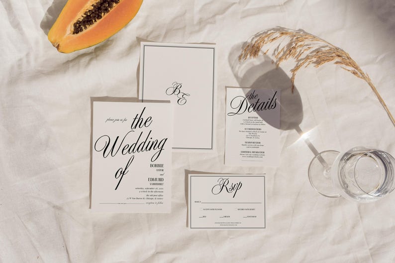 May include: Wedding invitation suite with a white background. The invitation cards feature black text with the words "the wedding of" and "RSVP".