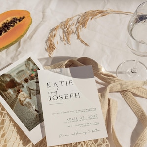 May include: A wedding invitation with a minimalist design featuring the names Katie and Joseph, the date April 23, 2025, and the location The Art Institute of Chicago. The invitation is printed on white cardstock and has a simple, elegant font.