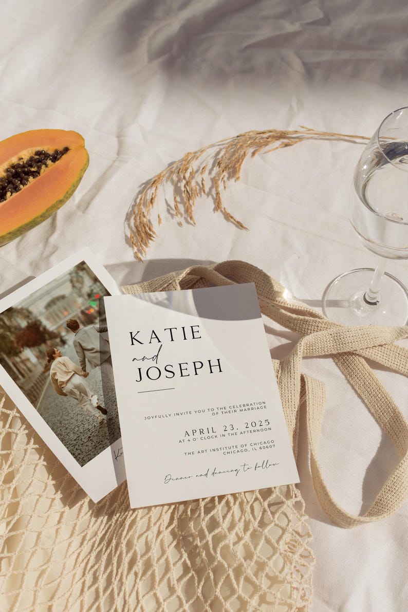 May include: A wedding invitation with a minimalist design featuring the names Katie and Joseph, the date April 23, 2025, and the location The Art Institute of Chicago. The invitation is printed on white cardstock and has a simple, elegant font.