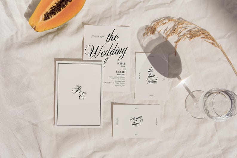 May include: Wedding invitation suite with white cards and black calligraphy. The cards include the text "the wedding", "B&E", "the finer details", and "see you there?"