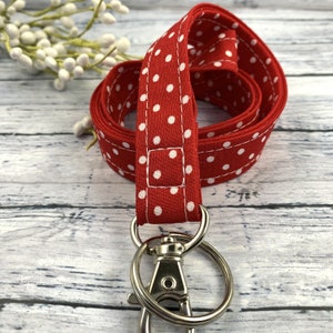 May include: Red and white polka dot lanyard with a silver swivel clip.