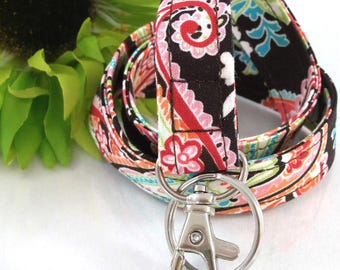 May include: A brown, pink, and blue paisley patterned fabric lanyard with a silver swivel clip.