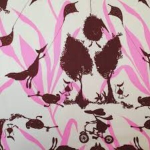 Pode incluir: Tecido com um padrão repetitivo de silhuetas castanhas caprichosas sobre um fundo branco, acentuado com linhas onduladas rosa. O design inclui figuras de animais, árvores e pipas.