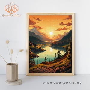 Puede incluir: Kit de pintura de diamantes con un paisaje escénico con un lago, montañas y una puesta de sol. El lago es de un azul vibrante, las montañas son de un verde intenso y la puesta de sol es de un naranja y amarillo cálido. La pintura está enmarcada en un marco de madera.