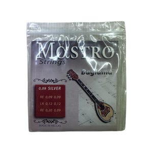 Op de afbeelding: Een zilverkleurig pakje Mastro Snaren voor een Baglama. Het pakje heeft de tekst "MASTRO Strings" en "Baglama". Rechts staat een afbeelding van een Baglama. Het pakje heeft ook de tekst "0,09 SILVER" en "MADE IN HELLAS".