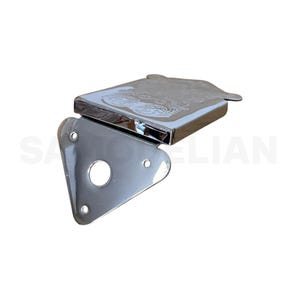Peut inclure: Une charnière métallique chromée brillante, avec un dessus rectangulaire orné d'un motif gravé et une base triangulaire. La base comporte un trou circulaire central et trois petits trous de montage. Les mots "SA" et "LIAN" sont partiellement visibles.