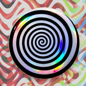 Hypnotiserende zwarte spiraalvormige badge met holografische reflecties – Op Art-werveling – 44 mm – Psychedelisch ontwerp – Handgemaakt