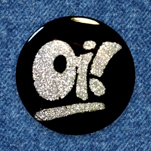 以下が含まれることがあります： 銀色のグリッターで「OK」と書かれた黒い丸いボタンです。