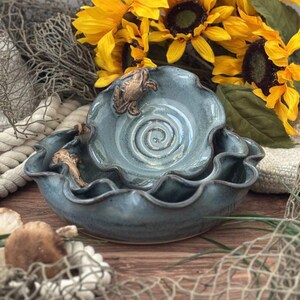May include: A handmade, wooden serving tray with a natural finish. The tray features a rectangular shape with rounded corners and raised edges. It is ideal for serving food and drinks. The dimensions are approximately 12 inches long, 8 inches wide, and 2 inches deep.