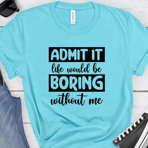 May include: A turquoise blue t-shirt with black text that reads "ADMIT IT life would be BORING without me".