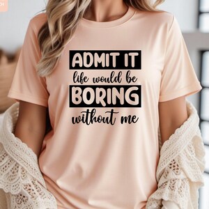May include: A peach-colored t-shirt with black text that reads "ADMIT IT life would be BORING without me".