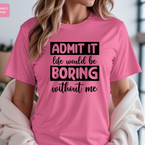 May include: Pink t-shirt with black text that reads "ADMIT IT life would be BORING without me"