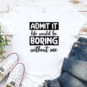 May include: White t-shirt with black text that reads "Admit it life would be boring without me".