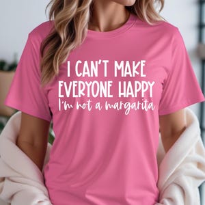 May include: Pink t-shirt with the text "I can't make everyone happy I'm not a margarita" in white.