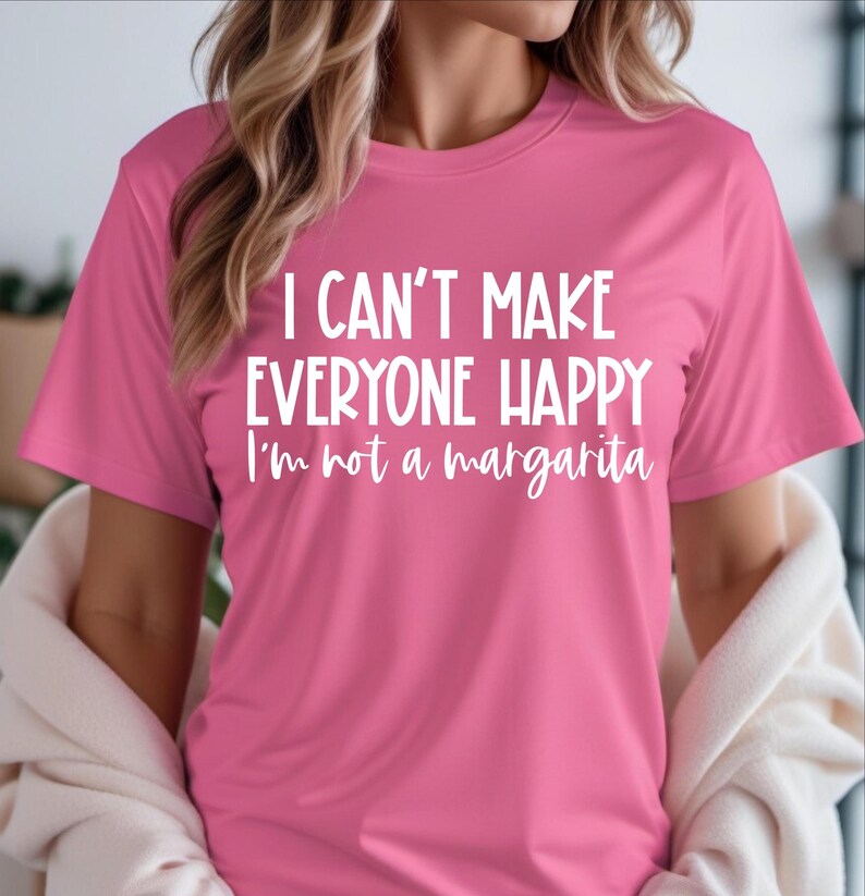 May include: Pink t-shirt with the text "I can't make everyone happy I'm not a margarita" in white.