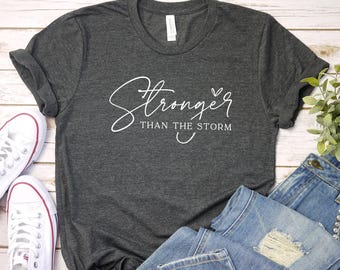 嵐よりも強いシャツ、宗教的なシャツ、モチベーションを高めるTシャツ、インスピレーションを与えるギフト、ポジティブなシャツ、クリスチャンTシャツ、女性用信仰Tシャツ