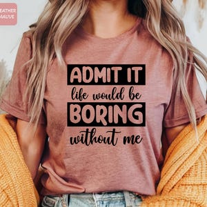 May include: A heather mauve t-shirt with the text "ADMIT IT life would be BORING without me" printed in black.