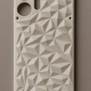 Peut inclure: Coque de téléphone blanc cassé avec un motif géométrique triangulaire. L'étui comporte des découpes pour l'appareil photo, le flash et d'autres fonctions du téléphone. Le motif est un motif répétitif de triangles en relief, créant une surface texturée.