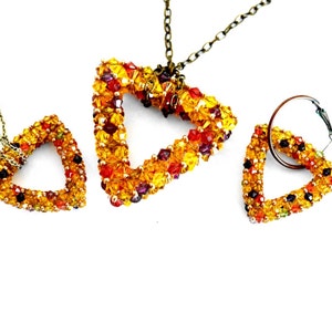Peut inclure: Un ensemble de bijoux en forme de triangle comprenant un collier et des boucles d'oreilles. Les bijoux sont faits de petites perles colorées dans les tons orange, jaune, rouge et violet. Le collier a une chaîne dorée.