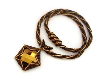 May include: A brown and gold beaded necklace with a large, faceted, gold-toned pendant.