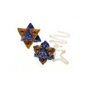 May include: Two beaded star-shaped pendants, one gold and one blue with red accents, hanging from a silver chain.