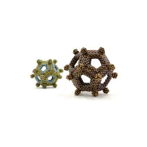 May include: Two beaded spheres, one brown and one green, with intricate geometric designs. The spheres are made of small beads and have a hollow center.