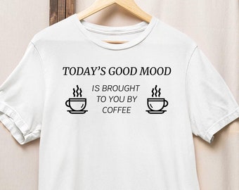 El buen humor de hoy te lo trae el café, un despertar divertido, necesito café, una divertida camiseta con gráfico de café