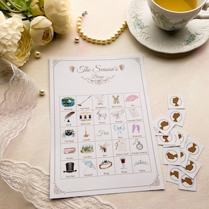 K&ouml;nnte beinhalten: Ein Vintage-Bingo-Spielkarte mit Illustrationen verschiedener Objekte, darunter eine Kutsche, ein Zylinder und ein Ring. Die Karte wird von kleinen Silhouette-Karten und einer Tasse Tee begleitet. Der Text "The Season's Bingo" steht oben.