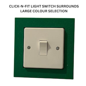 May include: A green light switch surround with a white light switch and a toggle switch. The text "CLICK-N-FIT LIGHT SWITCH SURROUNDS LARGE COLOUR SELECTION" is above the switch.