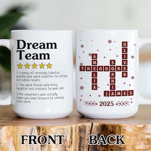 Op de afbeelding: Witte keramische mok met de woorden "Dream Team" in het zwart. De voorkant van de mok heeft een definitie van "Dream Team" en de achterkant een kruiswoordpuzzel met namen en het jaar 2025. De mok heeft een handvat.