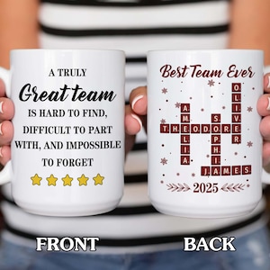 May include: White ceramic mug with the text "A Truly Great Team" and "Best Team Ever" on opposite sides. The front side has a quote and star icons. The back side has a crossword puzzle design with names and the year 2025.