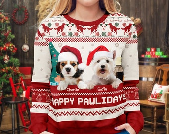 May include: A red, white, and green Christmas sweater featuring two dogs wearing Santa hats. The sweater has the words "HAPPY PAWLIDAYS" and the names "Charlie" and "Sofia". The sweater has a festive pattern with snowflakes and reindeer.