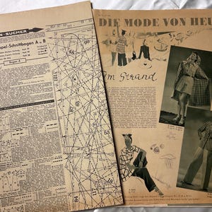 May include: A vintage 1939 German sewing pattern sheet titled Die Mode Von Heute, featuring black printed technical diagrams, numbered cutting lines, and illustrations of fashion models wearing plaid coats and striped blazers on a tan paper background.