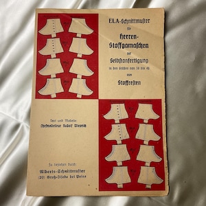 May include: Vintage sewing pattern titled "ELA-Schnittmuster für Herren-Stoffgamaschen" with diagrams of collar patterns. The pattern is printed on aged paper with red and cream-colored sections. Text includes the designer's name and the address for purchase.