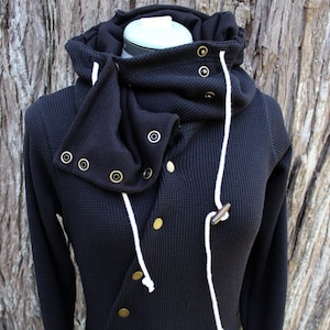 May include: Black waffle knit hooded sweatshirt with a high collar, a long white cord, and gold-toned button closures.