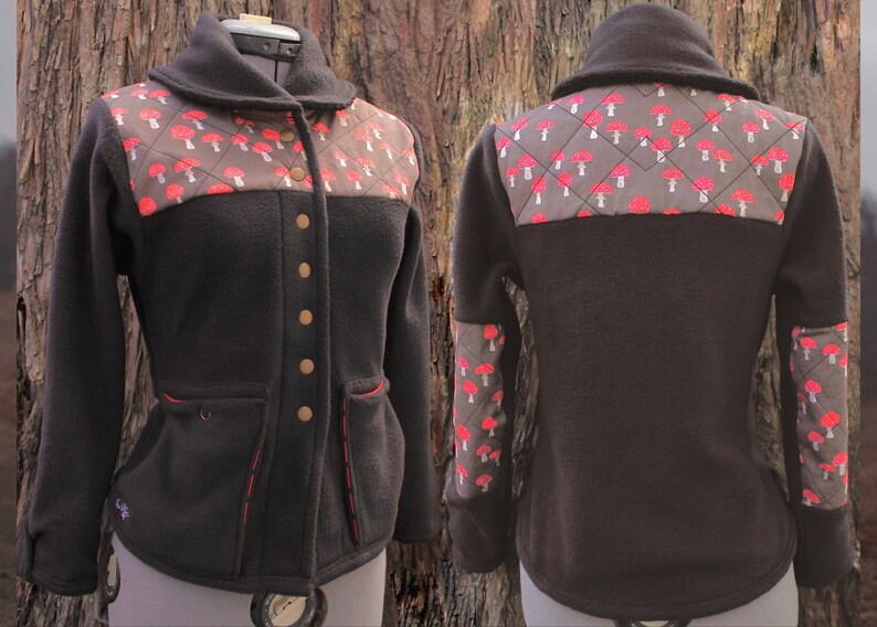 May include: A black fleece jacket with a brown and red mushroom pattern on the back and sleeves. The jacket has a collar, a button closure, and two pockets.