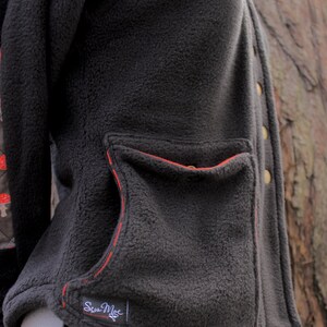 May include: Black fleece jacket with a red stitched pocket and a small black label that says "Sea Moe".