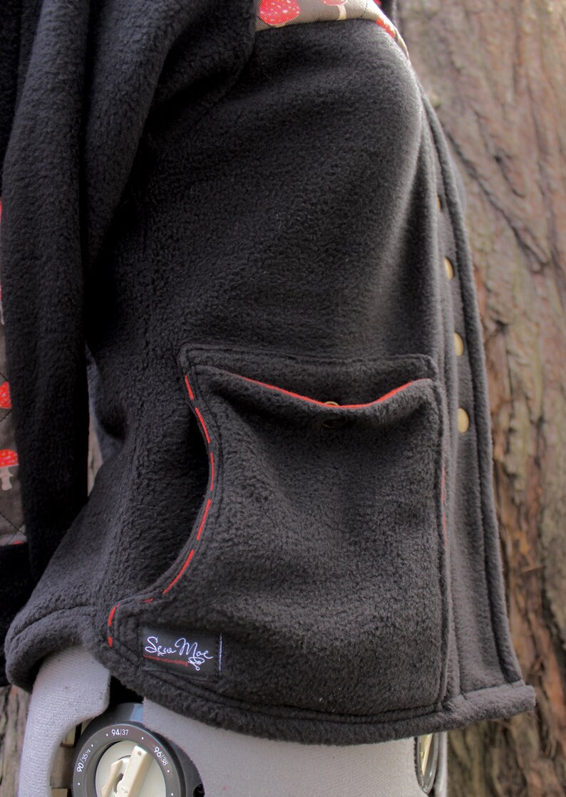 May include: Black fleece jacket with a red stitched pocket and a small black label that says "Sea Moe".