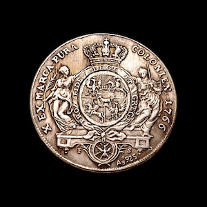 Könnte beinhalten: Eine detaillierte Silbermünze mit einem zentralen Wappen, einer Krone und verschiedenen Symbolen. Die Münze ist mit Text um die Ränder beschriftet, darunter "EX MARCA PURA" und "COLONIEN 1766". Die Münze hat auch den Text "Ag 925".