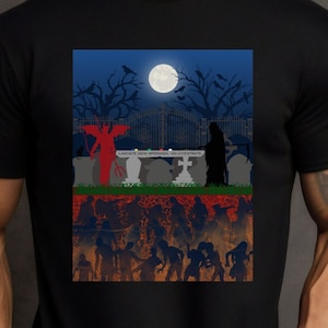 May include: Black t-shirt with a graphic print of a graveyard scene. The scene includes a devil, a reaper, and a crowd of zombies. The text on the tombstones reads "Land of the Living, Land of the Dead, Land of the Undead".